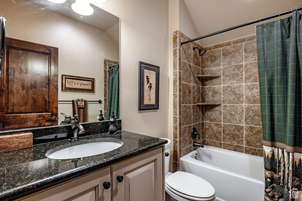 Full bathroom with vanity, toilet, and shower / bath combo with shower curtain