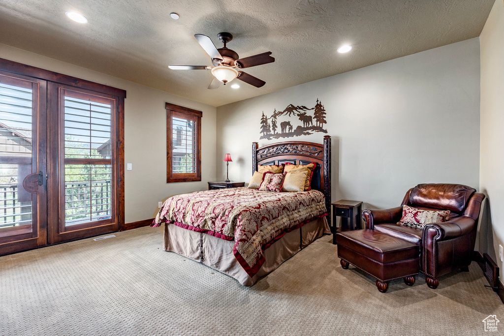 Bedroom with a textured ceiling, carpet floors, and ceiling fan