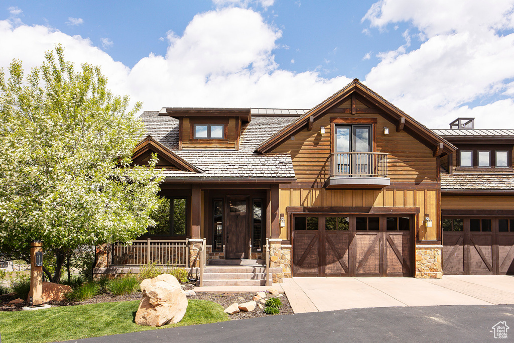 View of front of house with a garage and a balcony