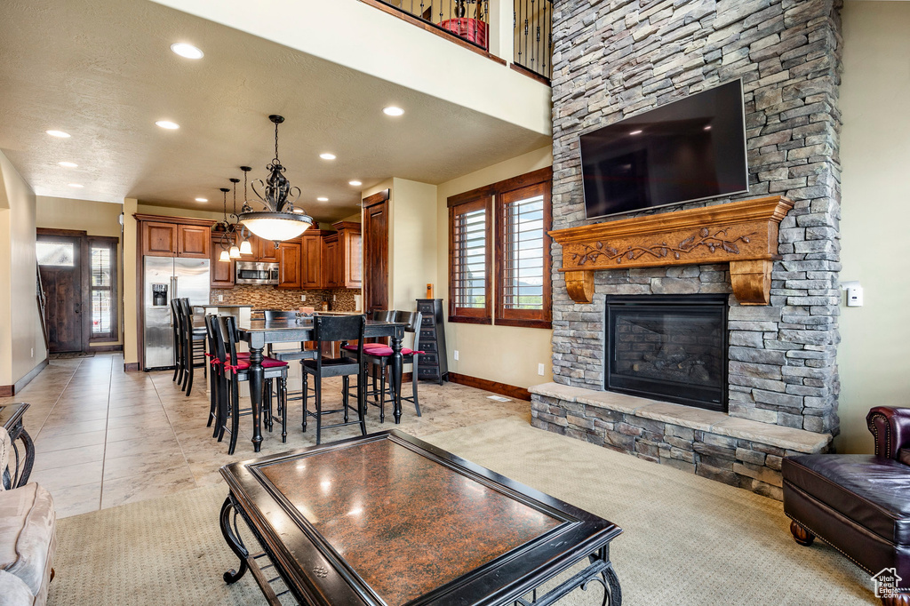 Living room featuring a healthy amount of sunlight, a stone fireplace, and light tile flooring