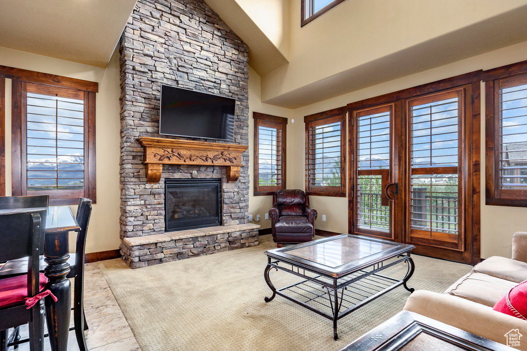 Carpeted living room featuring a fireplace and plenty of natural light