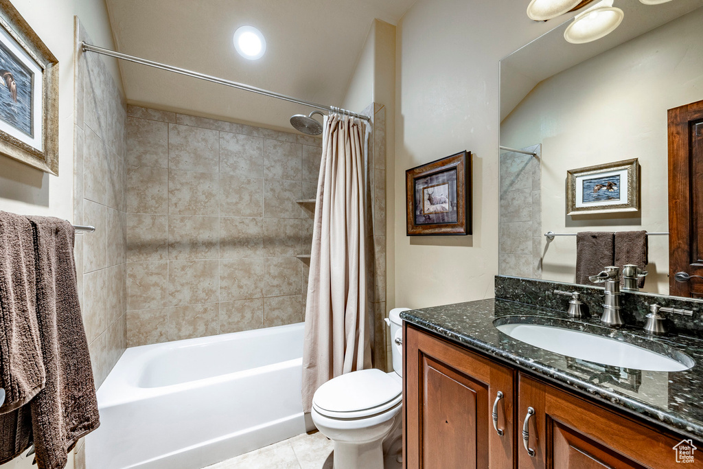 Full bathroom featuring vanity, toilet, tile floors, and shower / tub combo with curtain