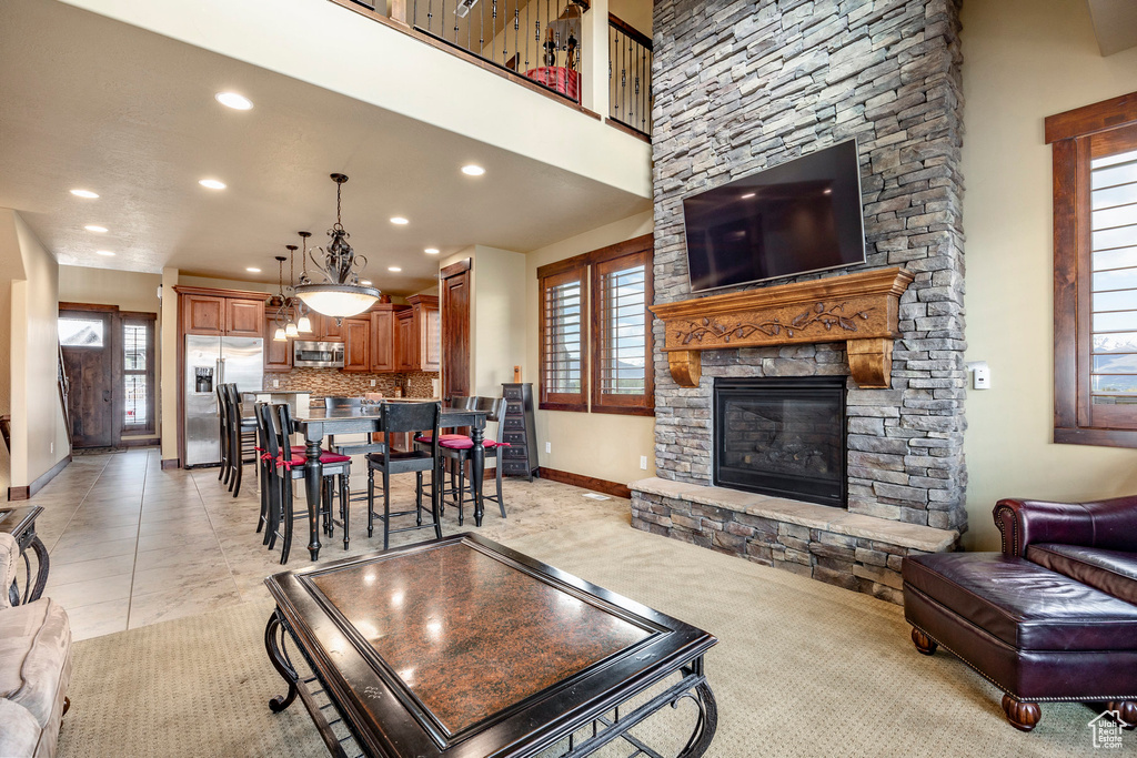 Living room featuring a healthy amount of sunlight, light tile flooring, and a fireplace