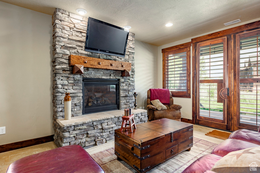 Tiled living room featuring a textured ceiling and a fireplace