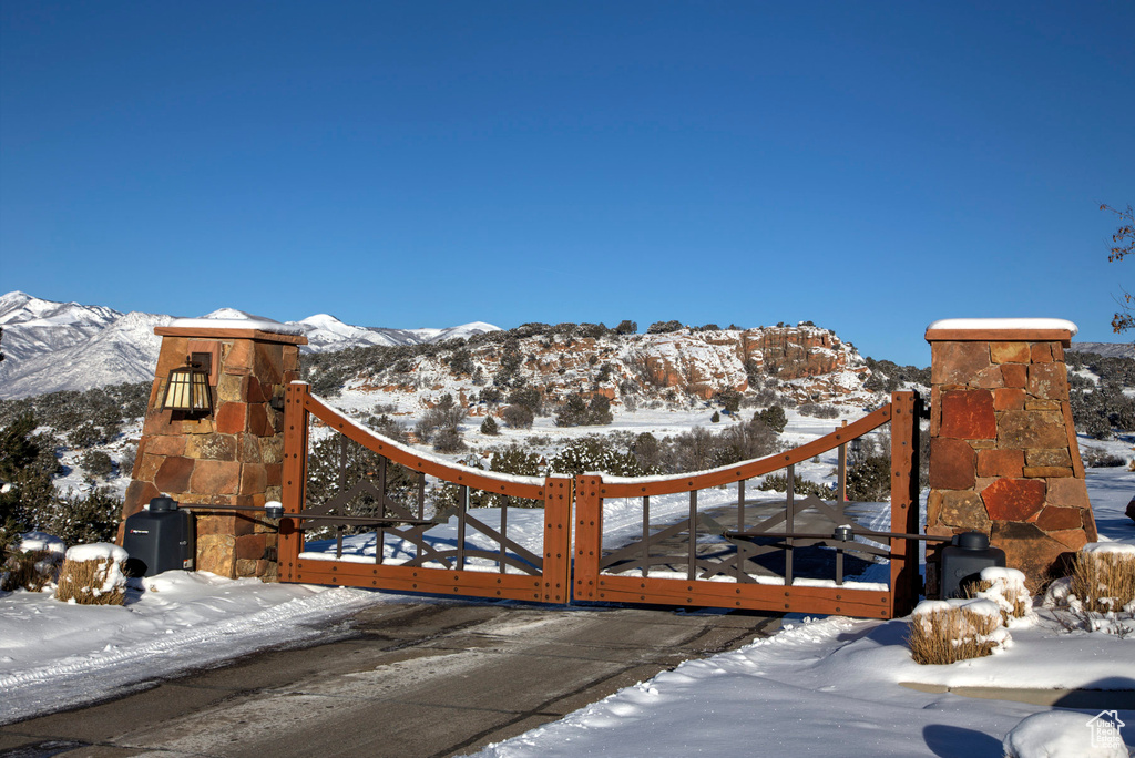 Snow covered gate featuring a mountain view