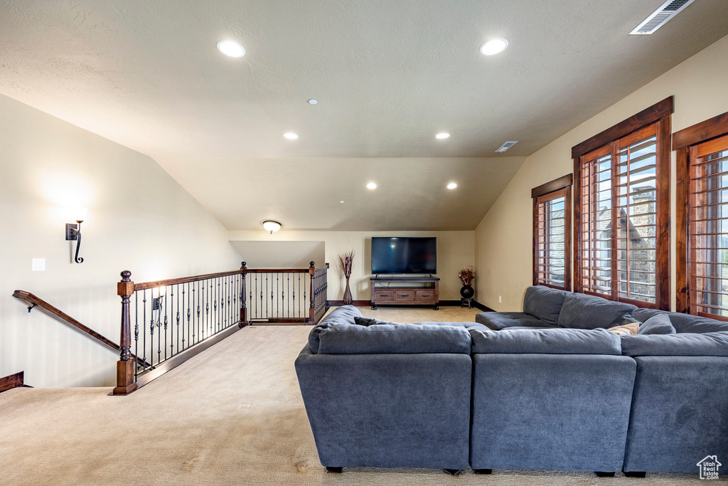 Carpeted living room with vaulted ceiling