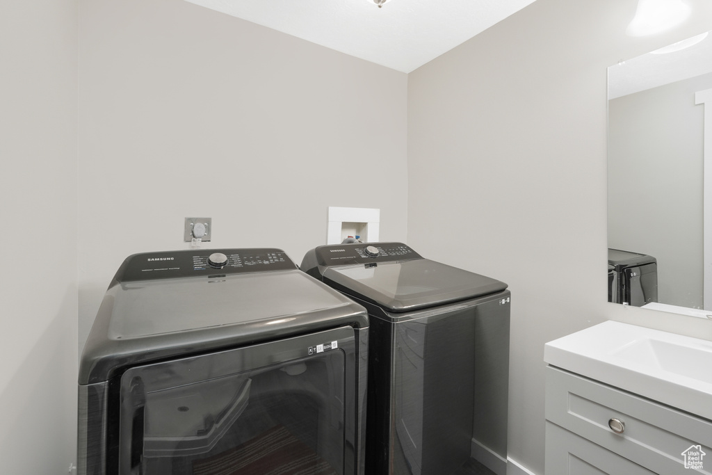 Washroom featuring sink, washing machine and clothes dryer, washer hookup, and electric dryer hookup