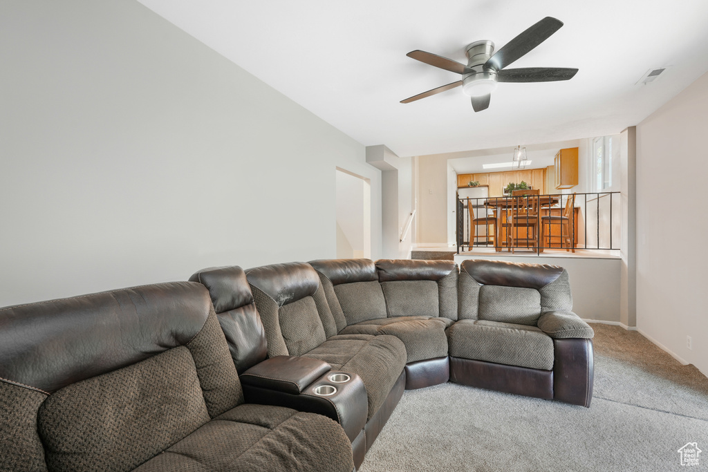 Living room with ceiling fan and light colored carpet