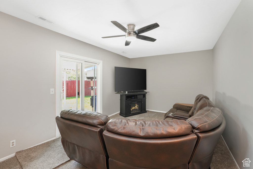 Carpeted living room with ceiling fan