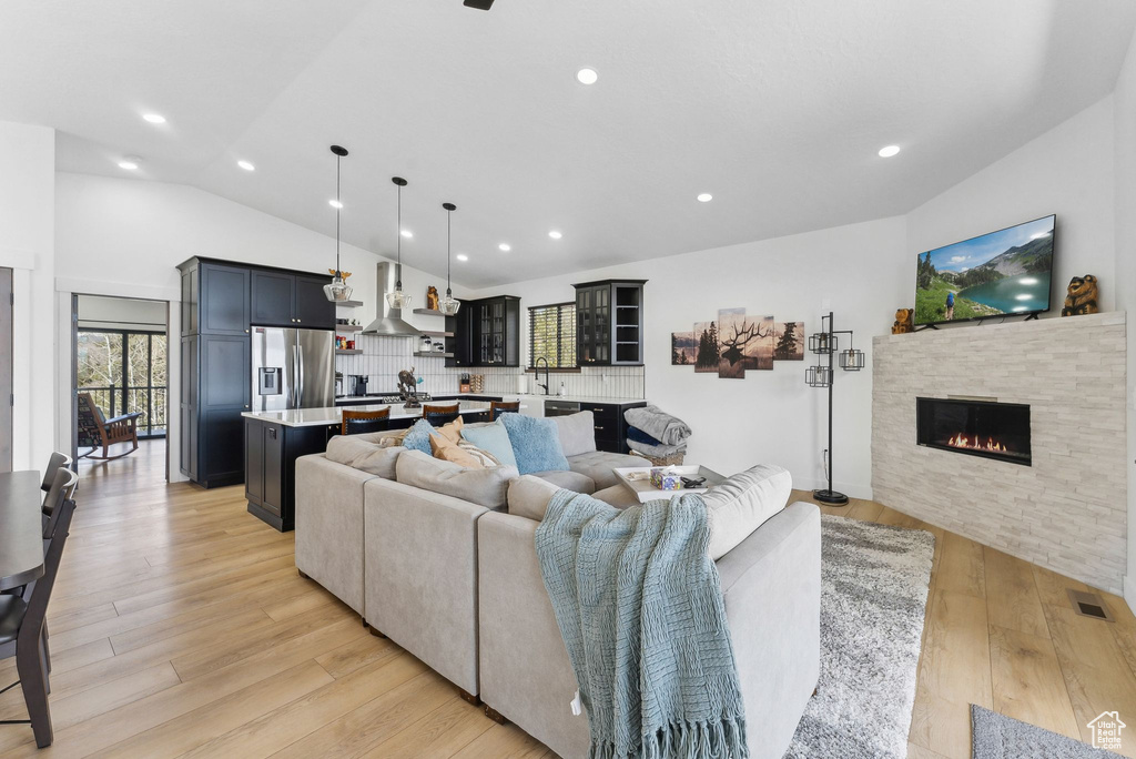 Living room with light hardwood / wood-style flooring and lofted ceiling