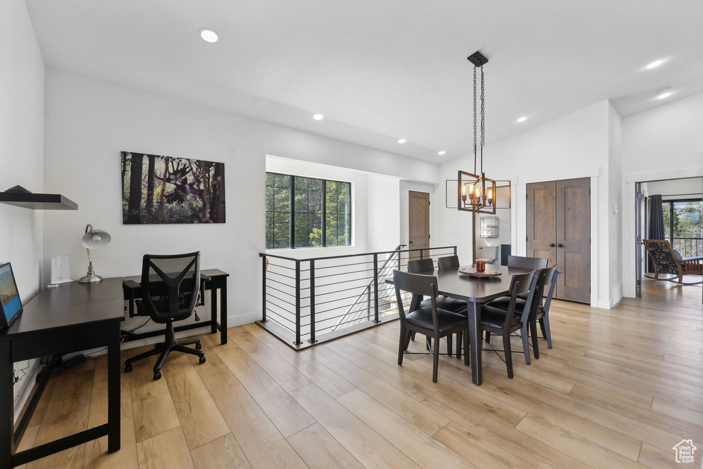 Dining area with a healthy amount of sunlight, vaulted ceiling, and light wood-type flooring