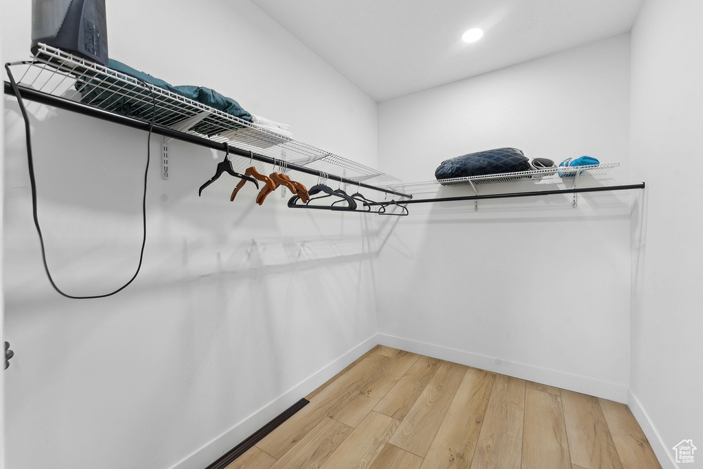 Spacious closet with light hardwood / wood-style flooring