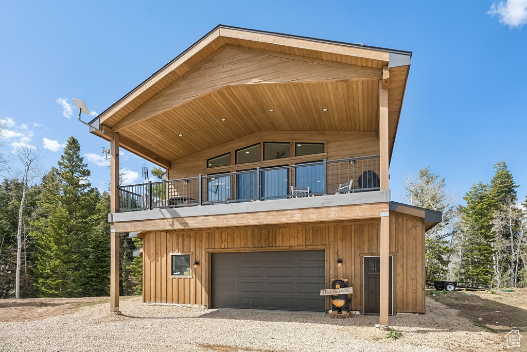 View of front of property featuring a garage and a balcony