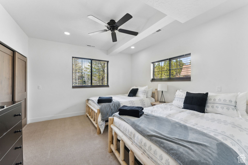 Bedroom featuring light colored carpet, a closet, ceiling fan, and multiple windows