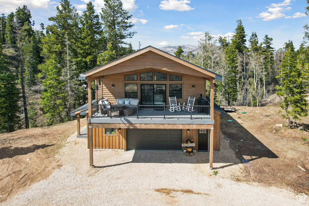 View of front of house featuring a deck and a garage
