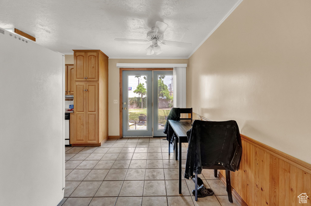 Dining room with french doors, ceiling fan, light tile floors, and crown molding