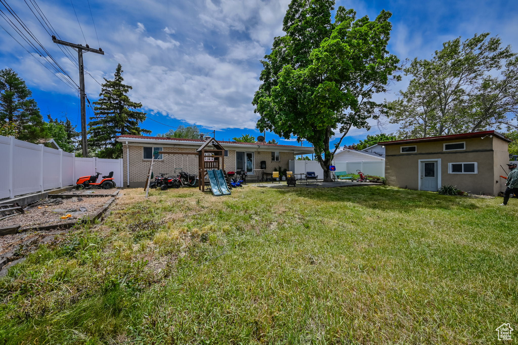 Back of house featuring a patio area and a lawn