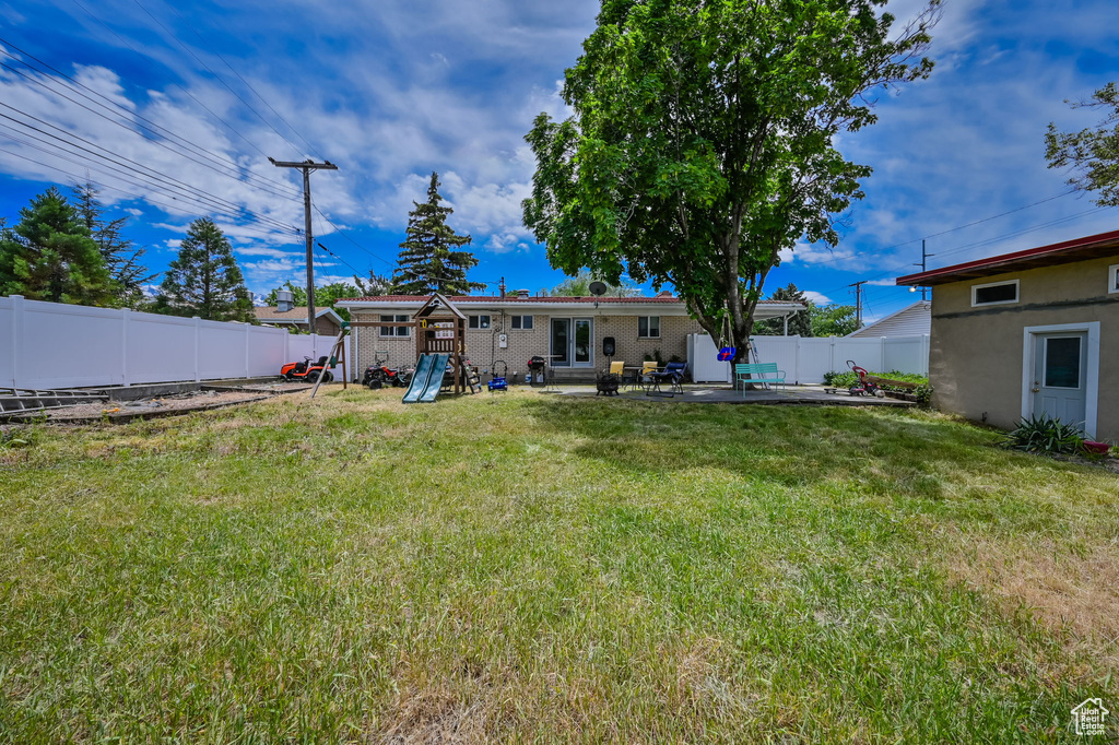 Back of property with a patio and a lawn