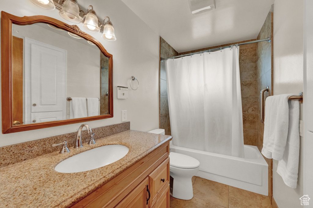 Full bathroom with tile flooring, toilet, shower / tub combo, and oversized vanity