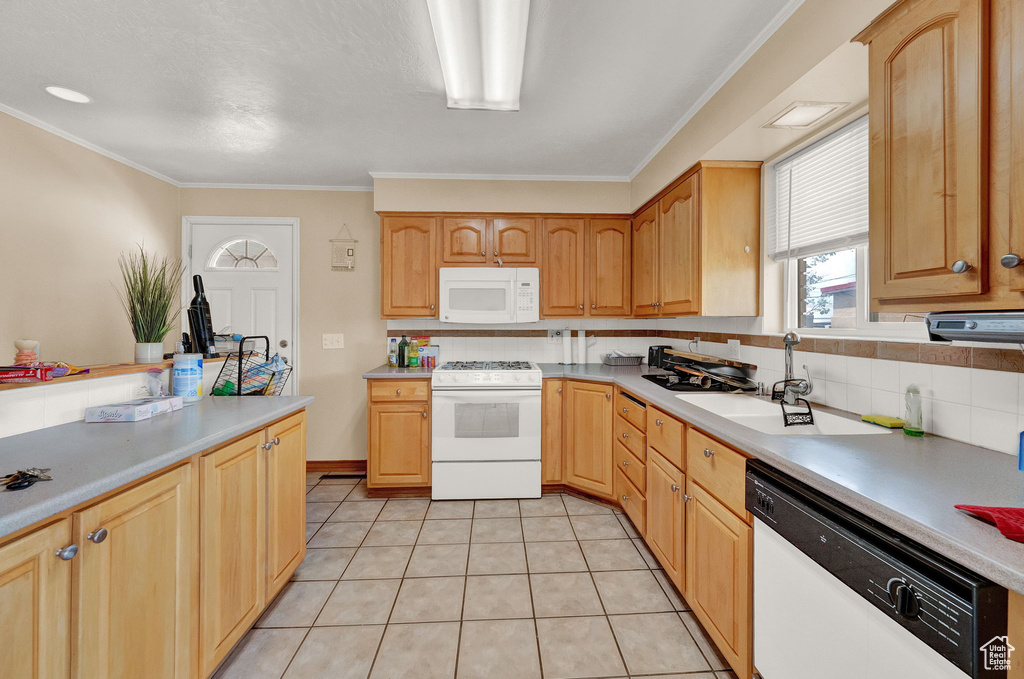 Kitchen featuring light tile flooring, tasteful backsplash, crown molding, sink, and white appliances