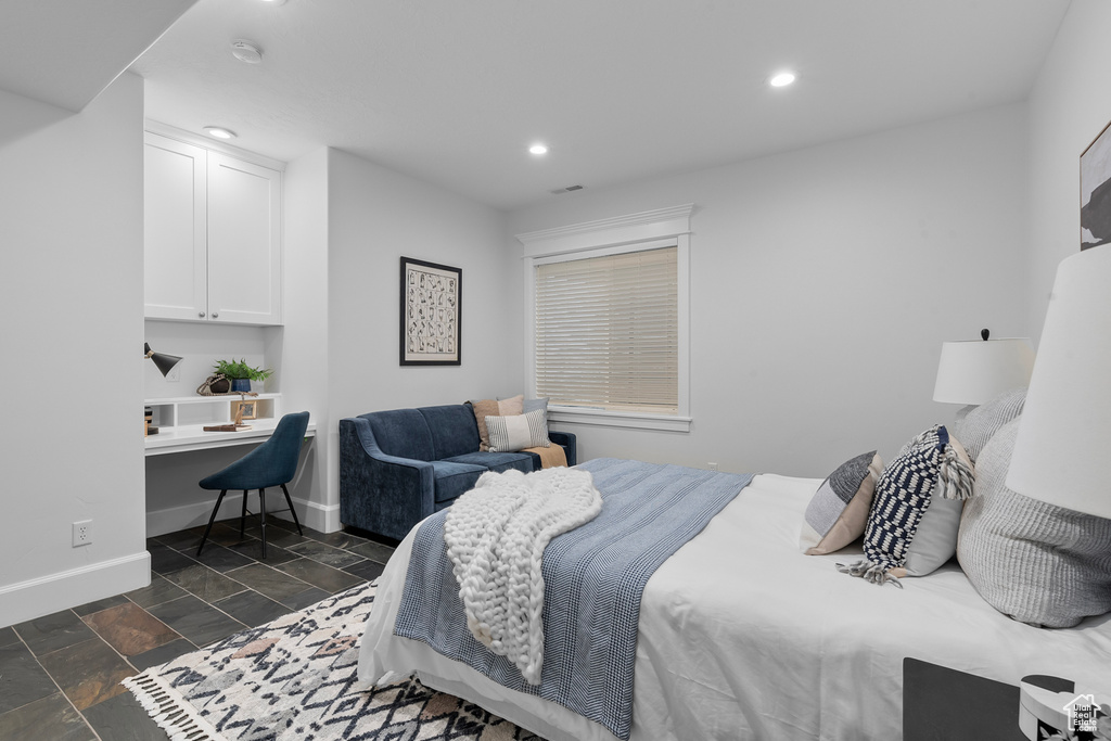 Tiled bedroom featuring built in desk