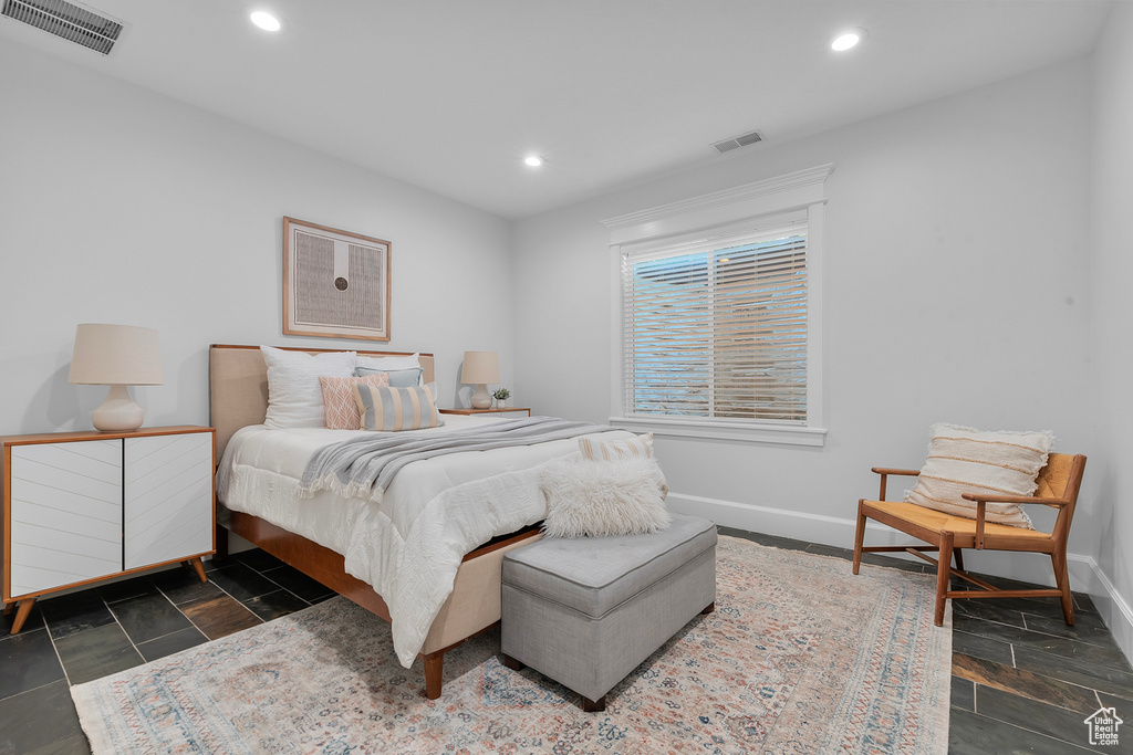 Bedroom with dark tile flooring