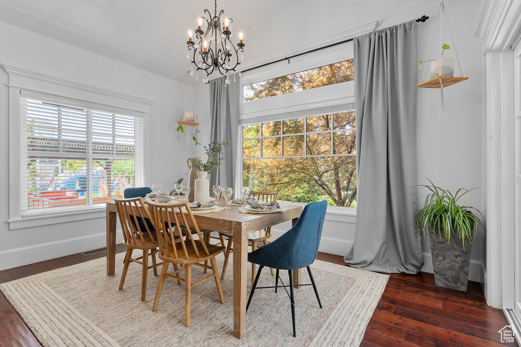 Dining space with wood-type flooring and an inviting chandelier