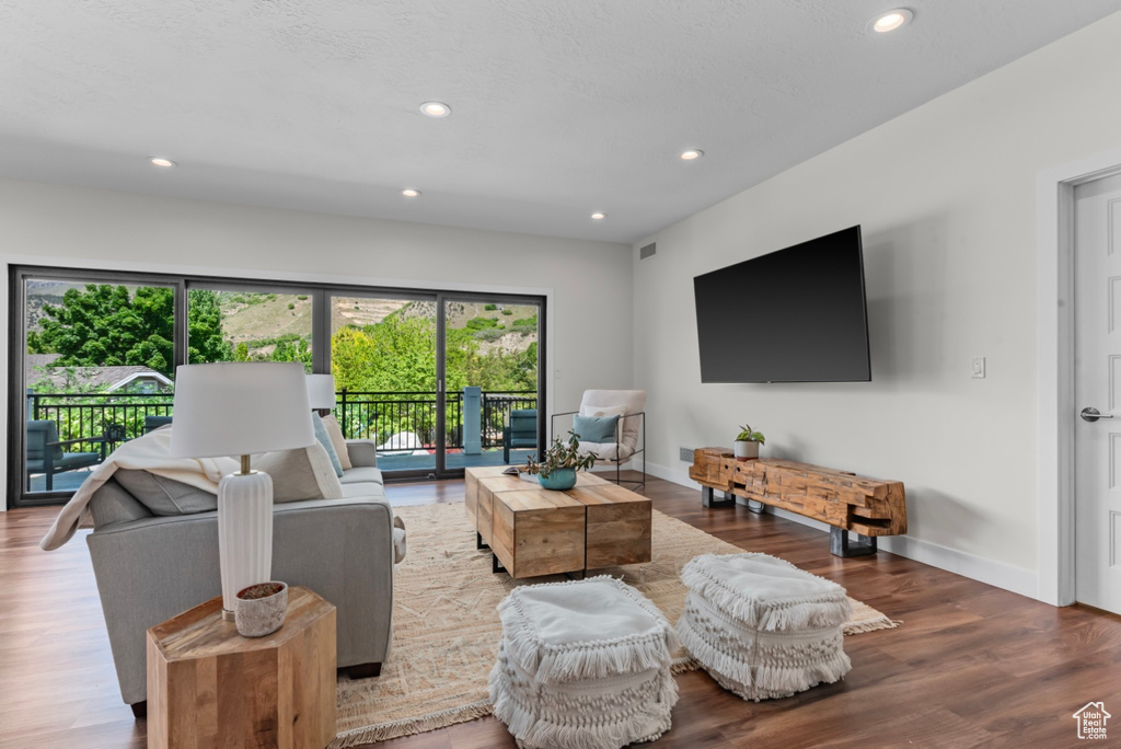 Living room with a healthy amount of sunlight and hardwood / wood-style flooring