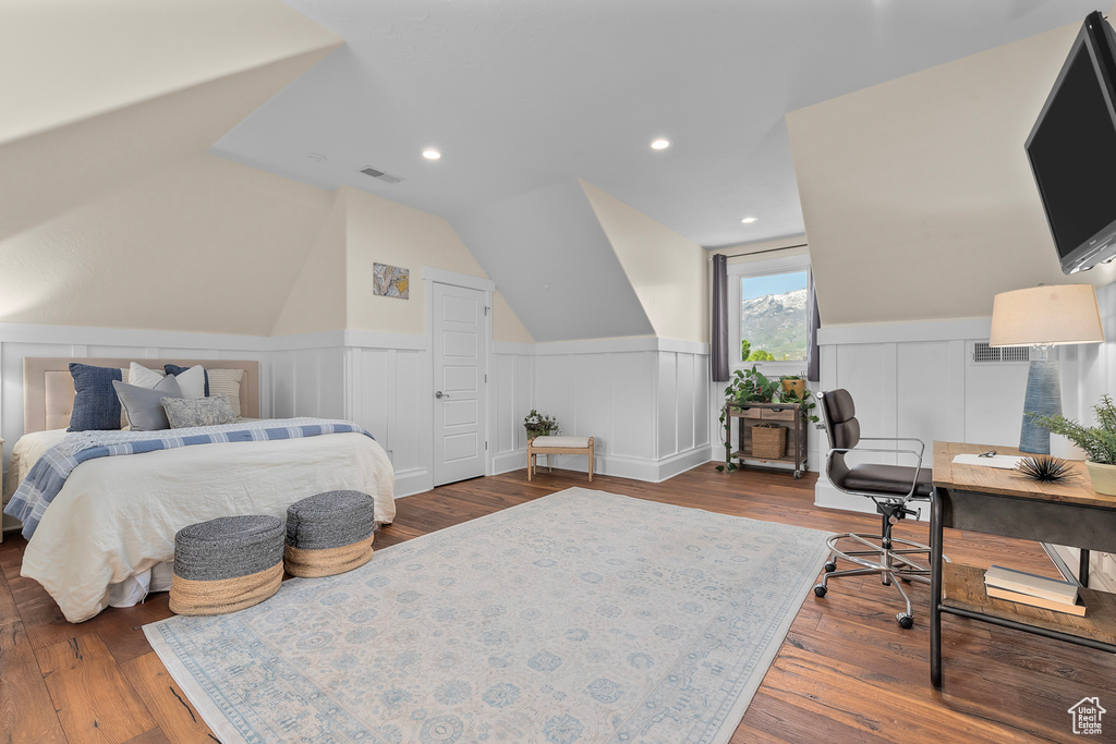 Bedroom with hardwood / wood-style floors and lofted ceiling