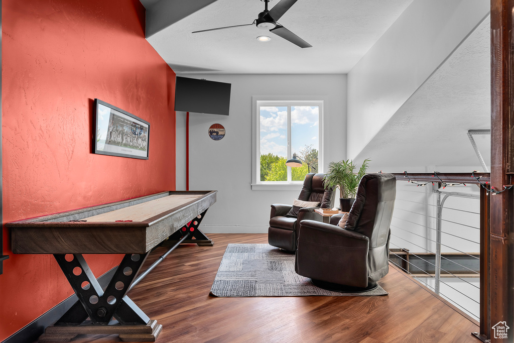 Game room with dark wood-type flooring and ceiling fan