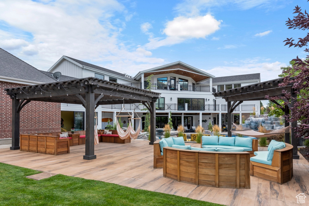 Exterior space with a pergola, an outdoor living space with a fire pit, a balcony, and an outdoor bar