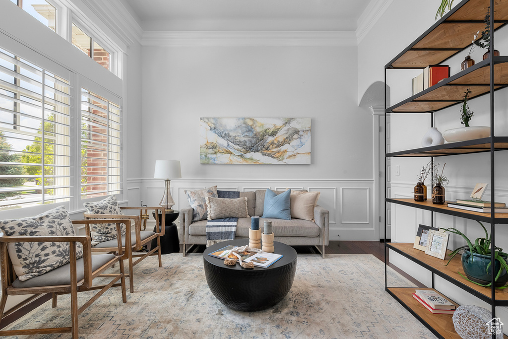 Living room with a healthy amount of sunlight, hardwood / wood-style flooring, and ornamental molding