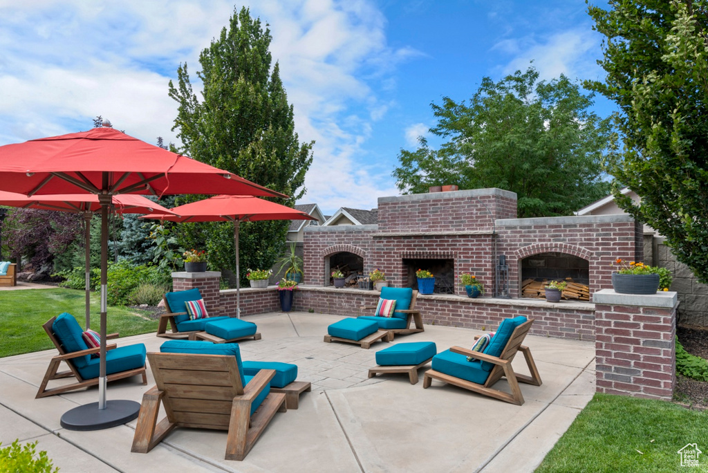 View of patio / terrace featuring an outdoor brick fireplace