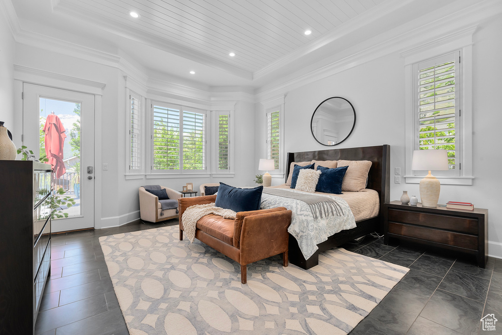 Bedroom featuring dark tile floors, a raised ceiling, access to outside, and ornamental molding