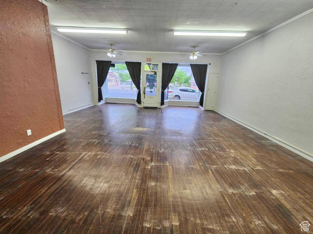 Spare room with ceiling fan, dark hardwood / wood-style floors, and crown molding