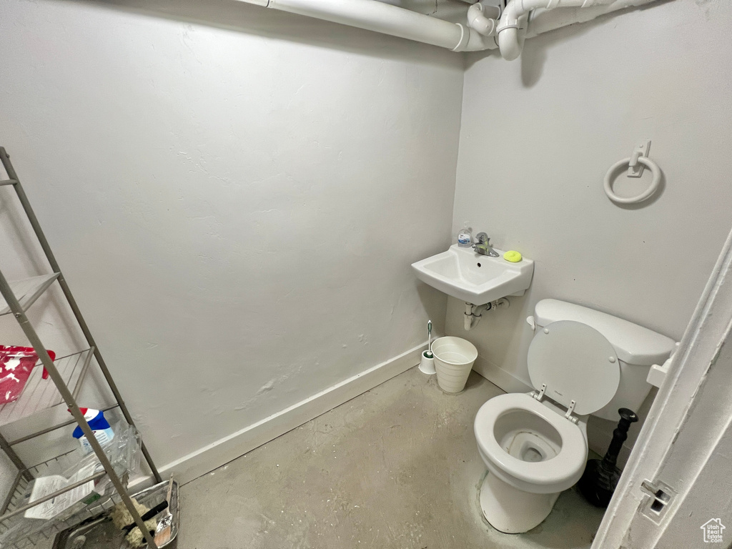 Bathroom with sink, concrete floors, and toilet