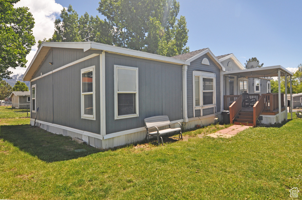 Rear view of property featuring a deck and a lawn