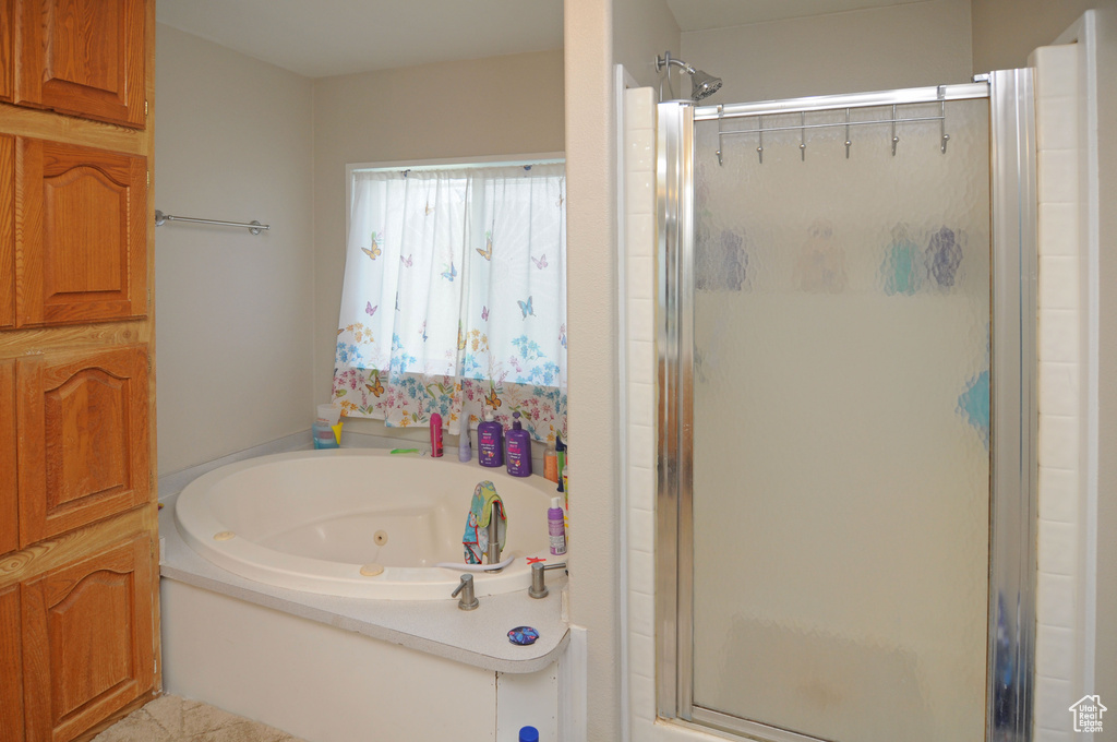 Bathroom with tile flooring and plus walk in shower