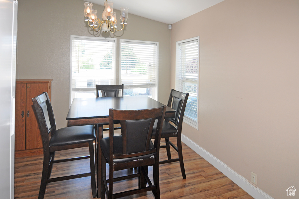 Dining area featuring a notable chandelier and hardwood / wood-style floors