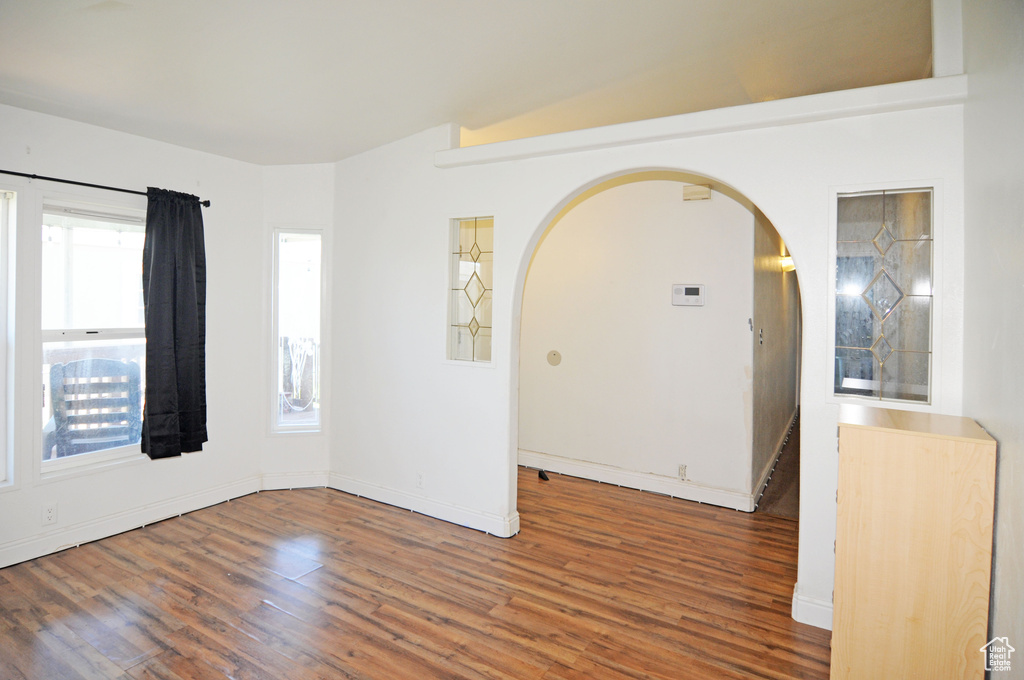 Unfurnished room with hardwood / wood-style flooring and lofted ceiling