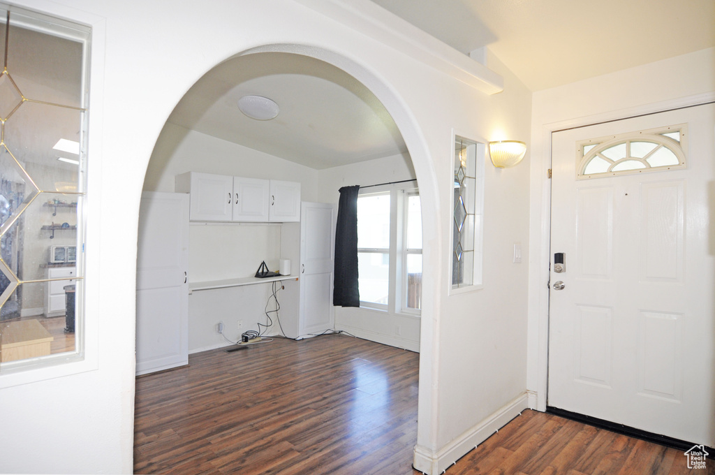 Foyer with dark hardwood / wood-style floors, plenty of natural light, and lofted ceiling