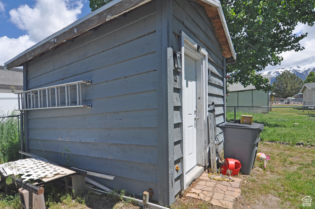 View of side of property with a storage shed and a yard