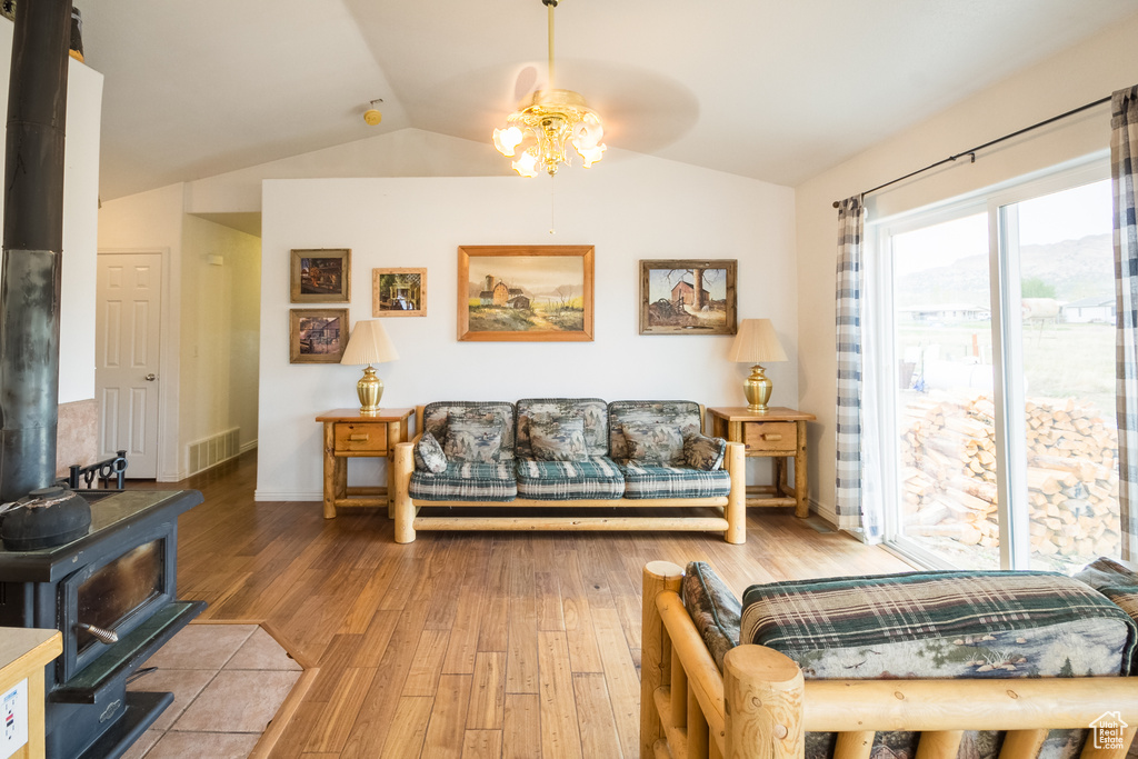 Living room featuring ceiling fan, hardwood / wood-style flooring, and lofted ceiling