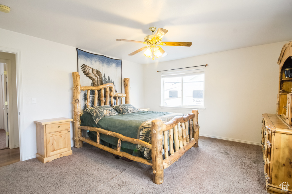 Carpeted bedroom featuring ceiling fan