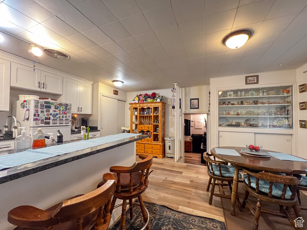 Kitchen featuring white refrigerator, white cabinetry, and light hardwood / wood-style floors