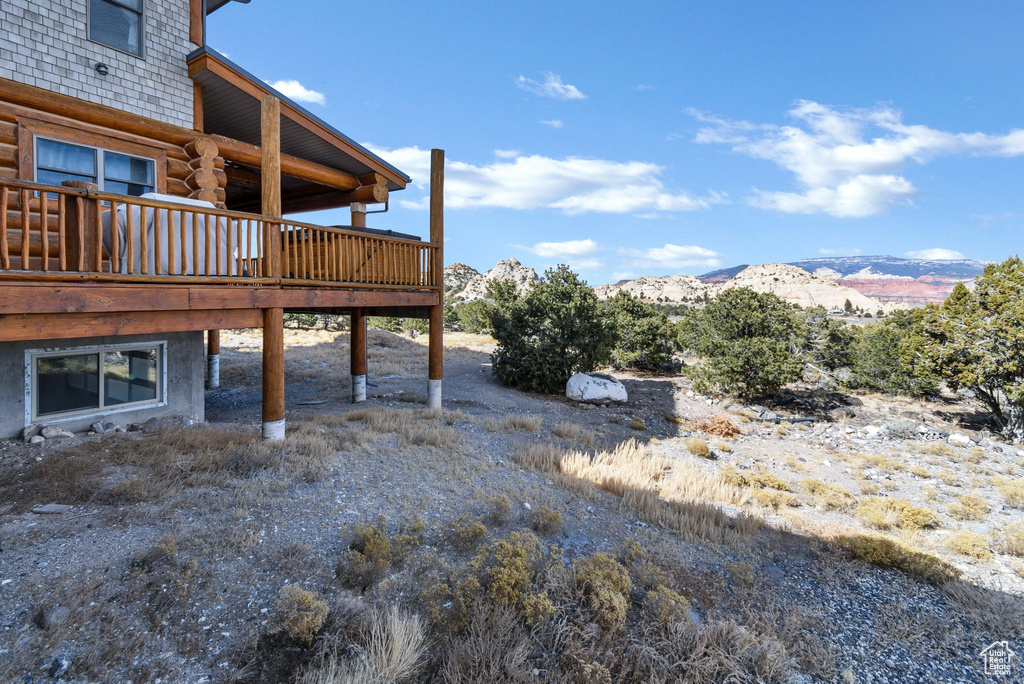 View of yard with a deck with mountain view
