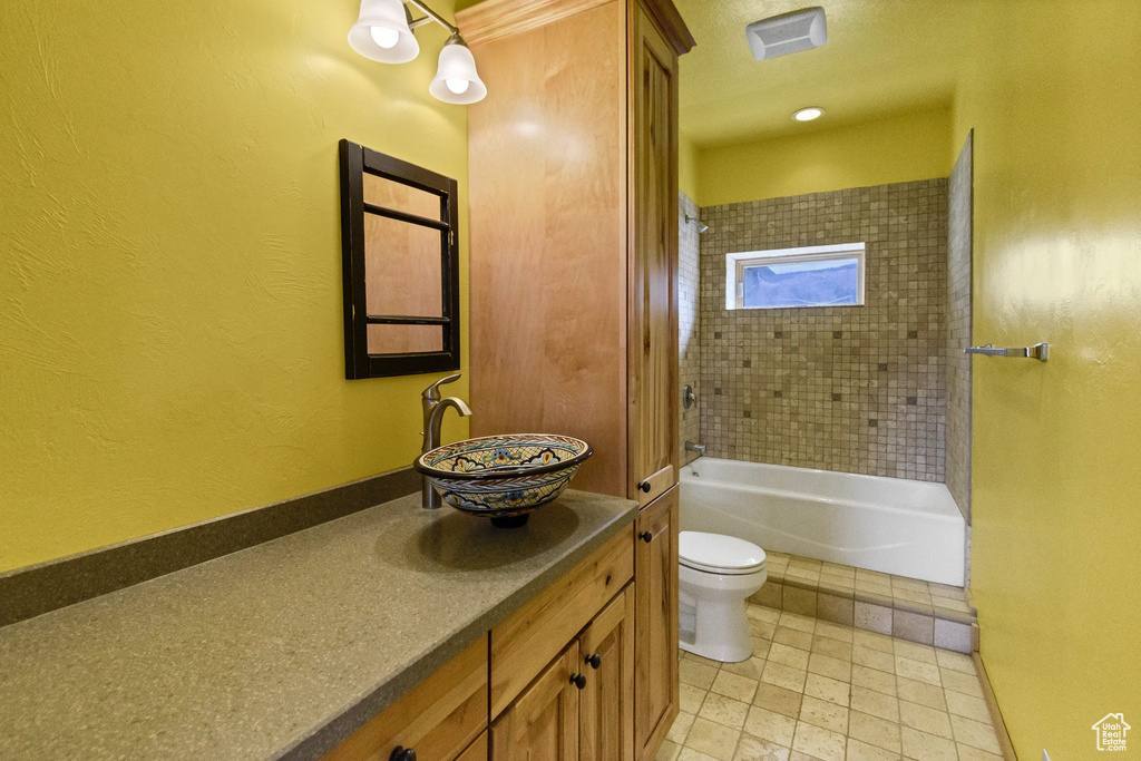 Full bathroom with a textured wall, shower / washtub combination, vanity, and toilet