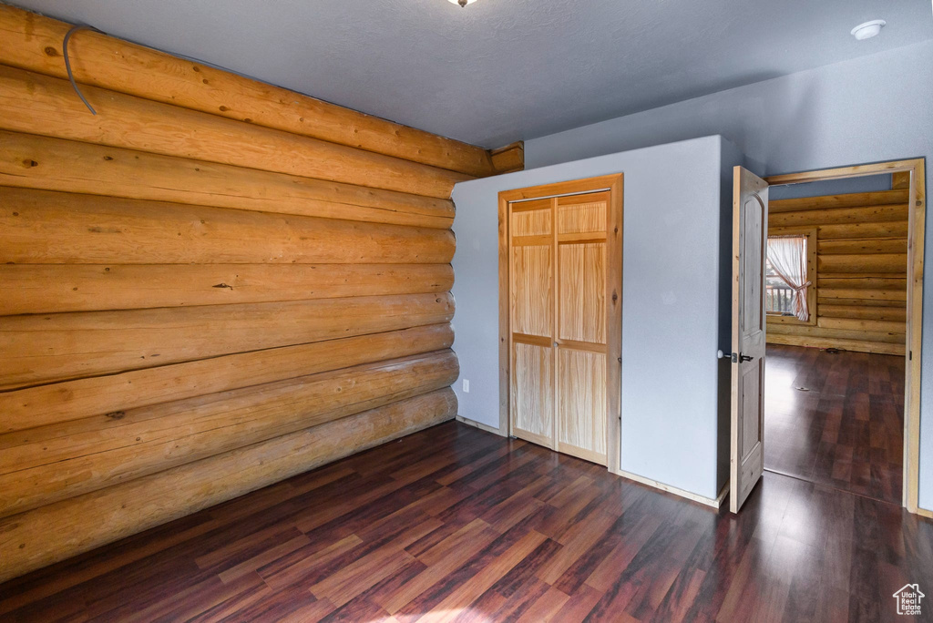 Unfurnished bedroom with dark wood-type flooring