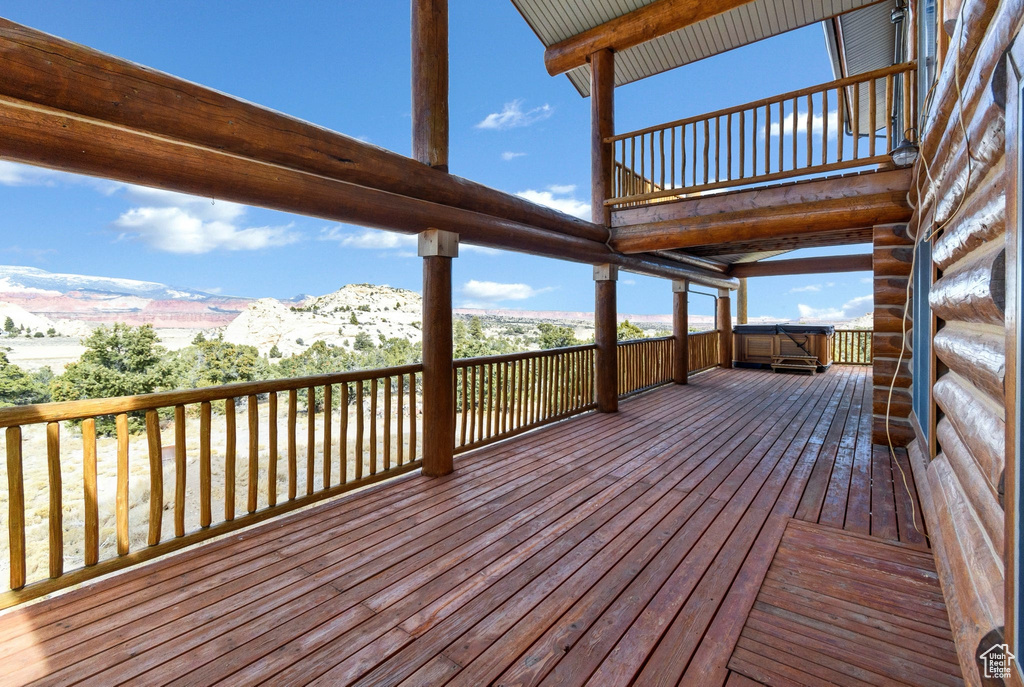 Deck with a mountain view and a hot tub
