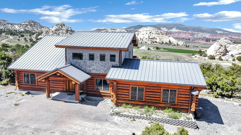 Cabin featuring metal roof, a standing seam roof, log siding, and a mountain view